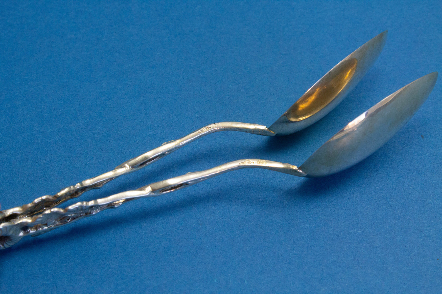 2 silver teaspoons with a rose pattern