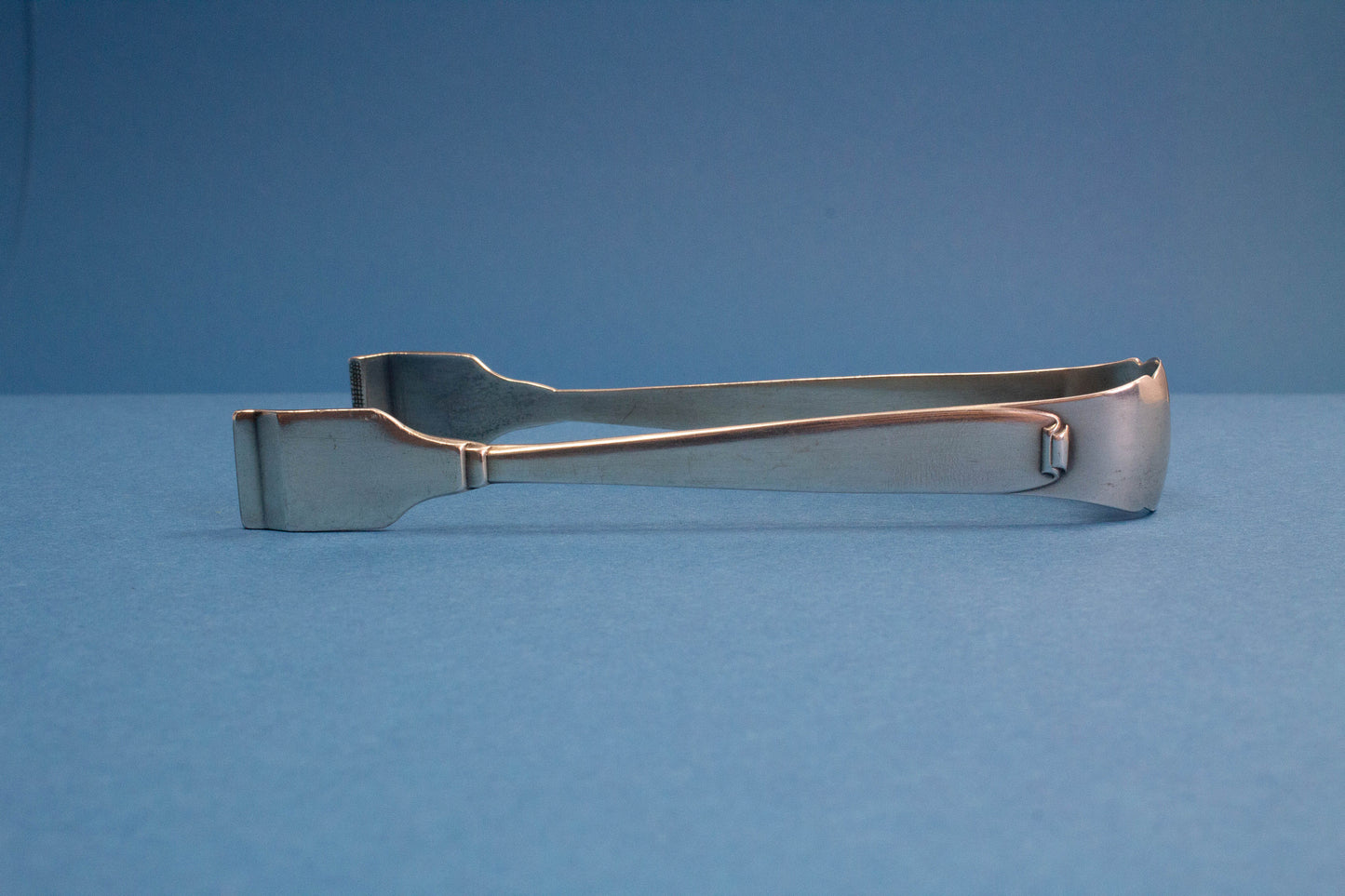 Silver plated sugar tongs with art deco pattern