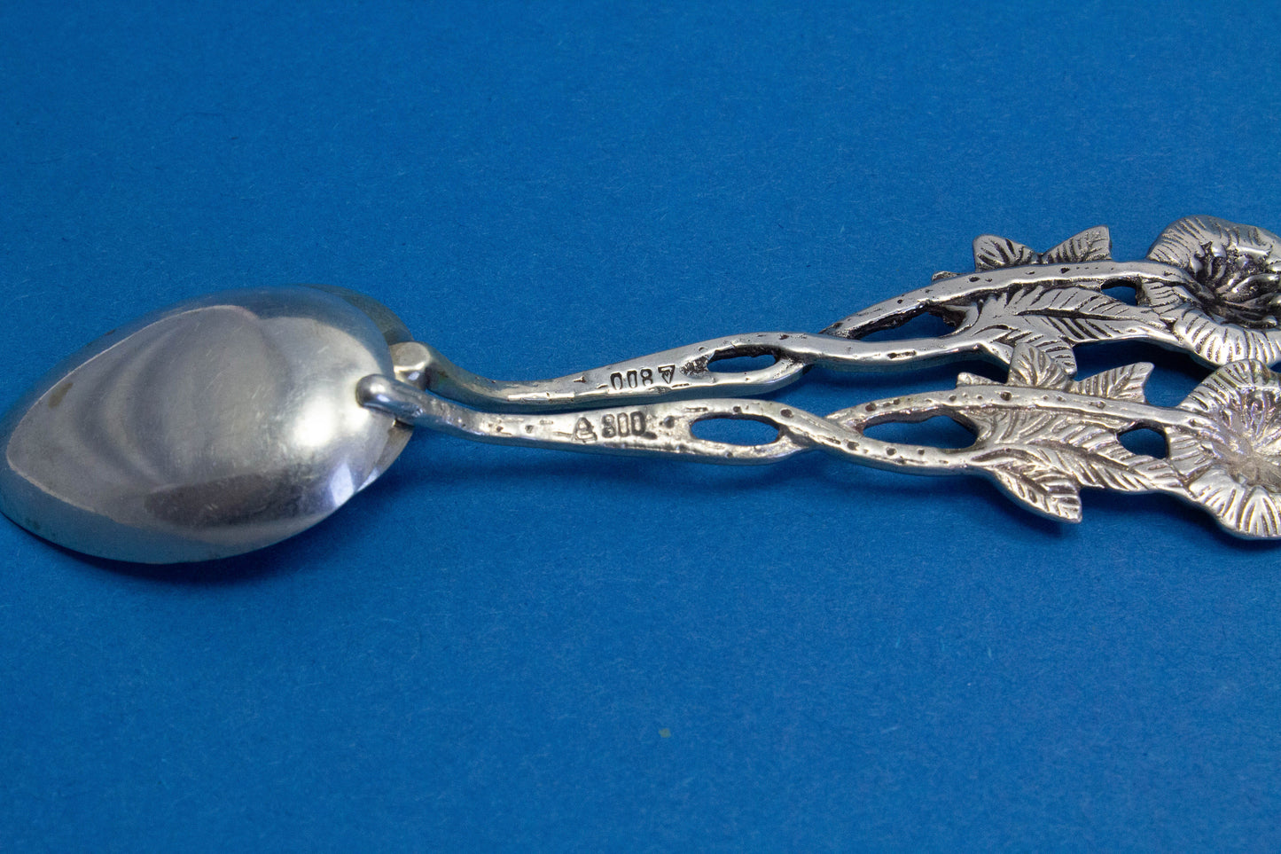 2 silver teaspoons with a rose pattern